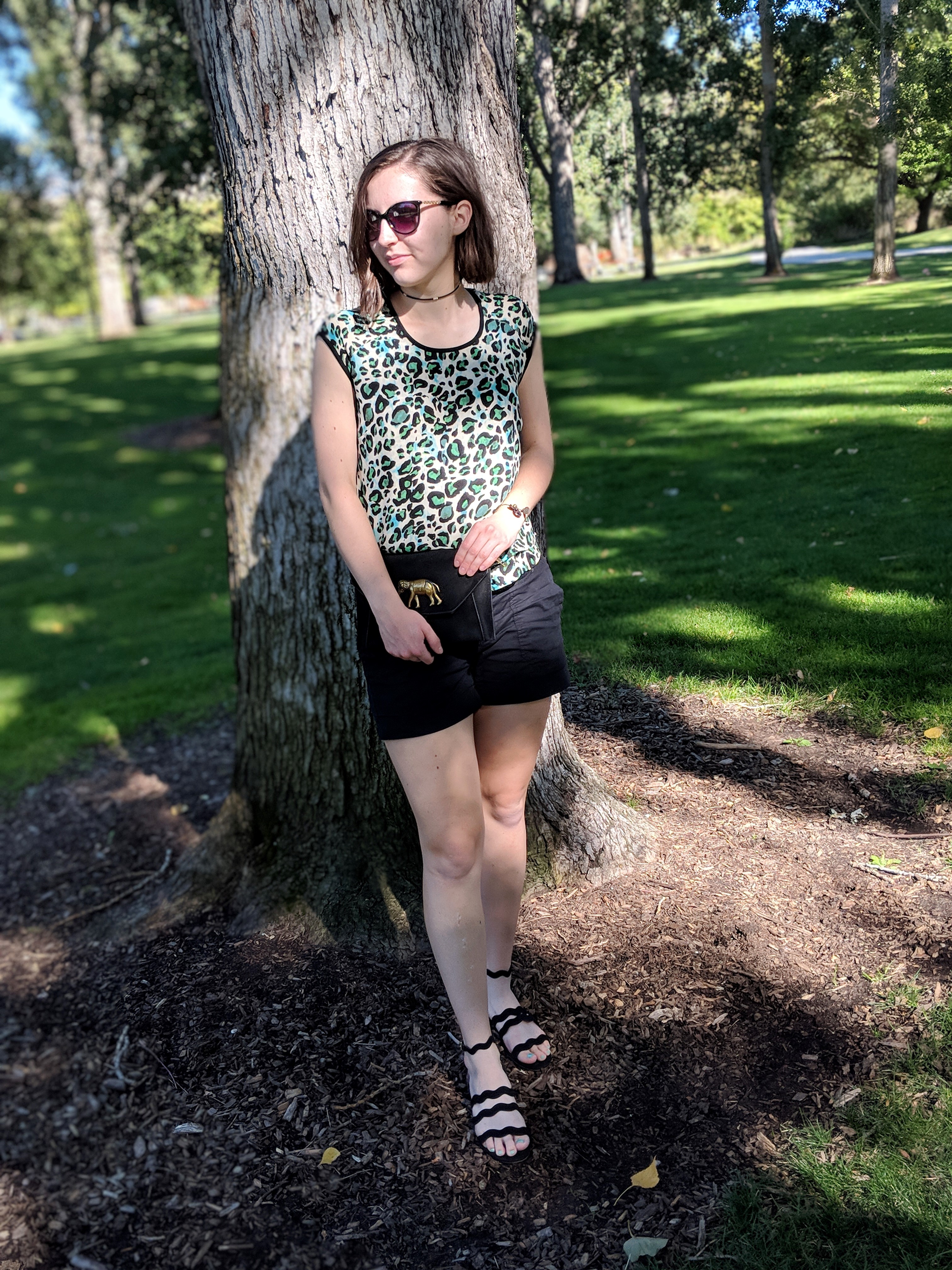 green leopard blouse, black shorts, black sandals