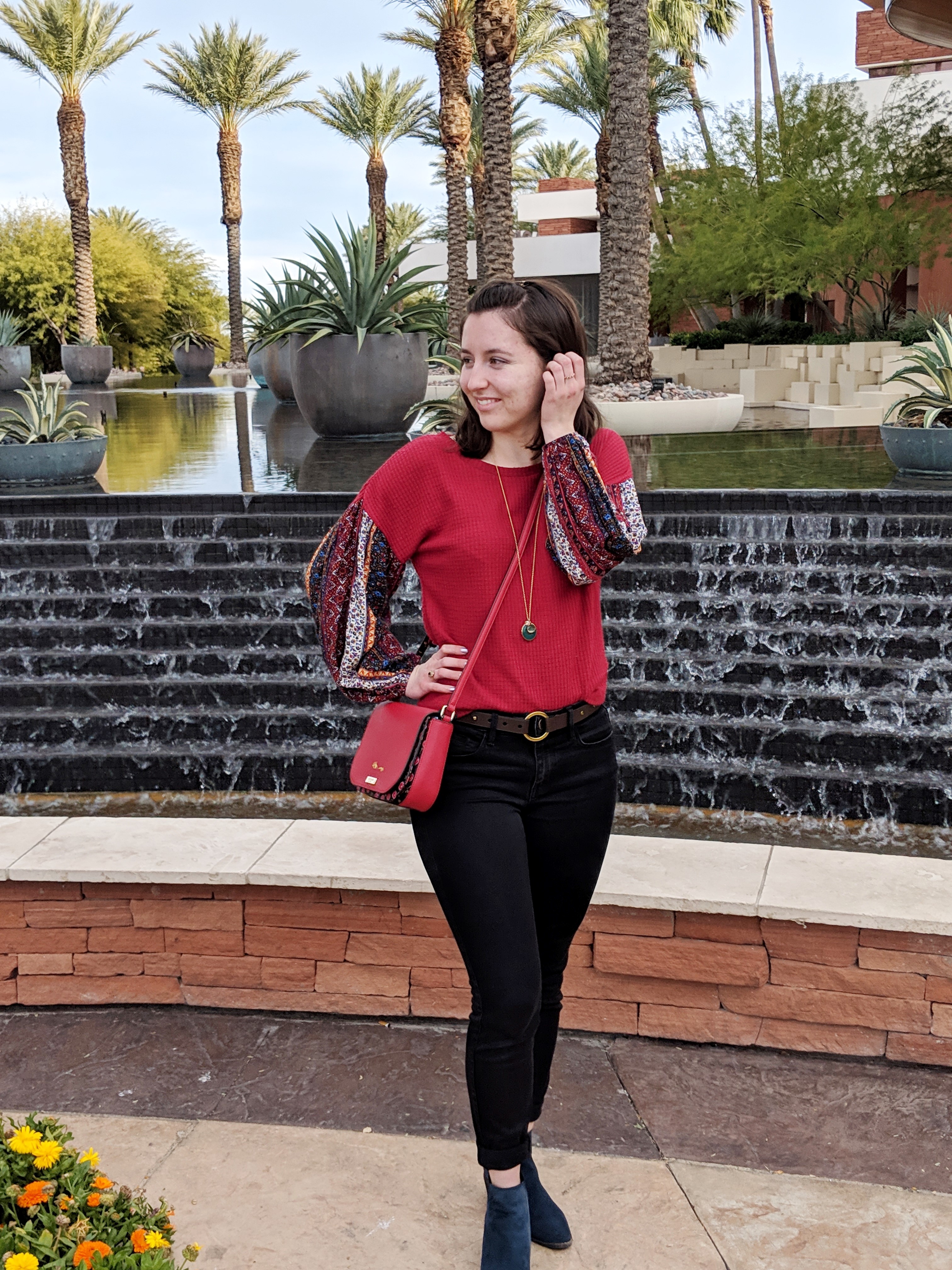 red patterned blouse black jeans red purse