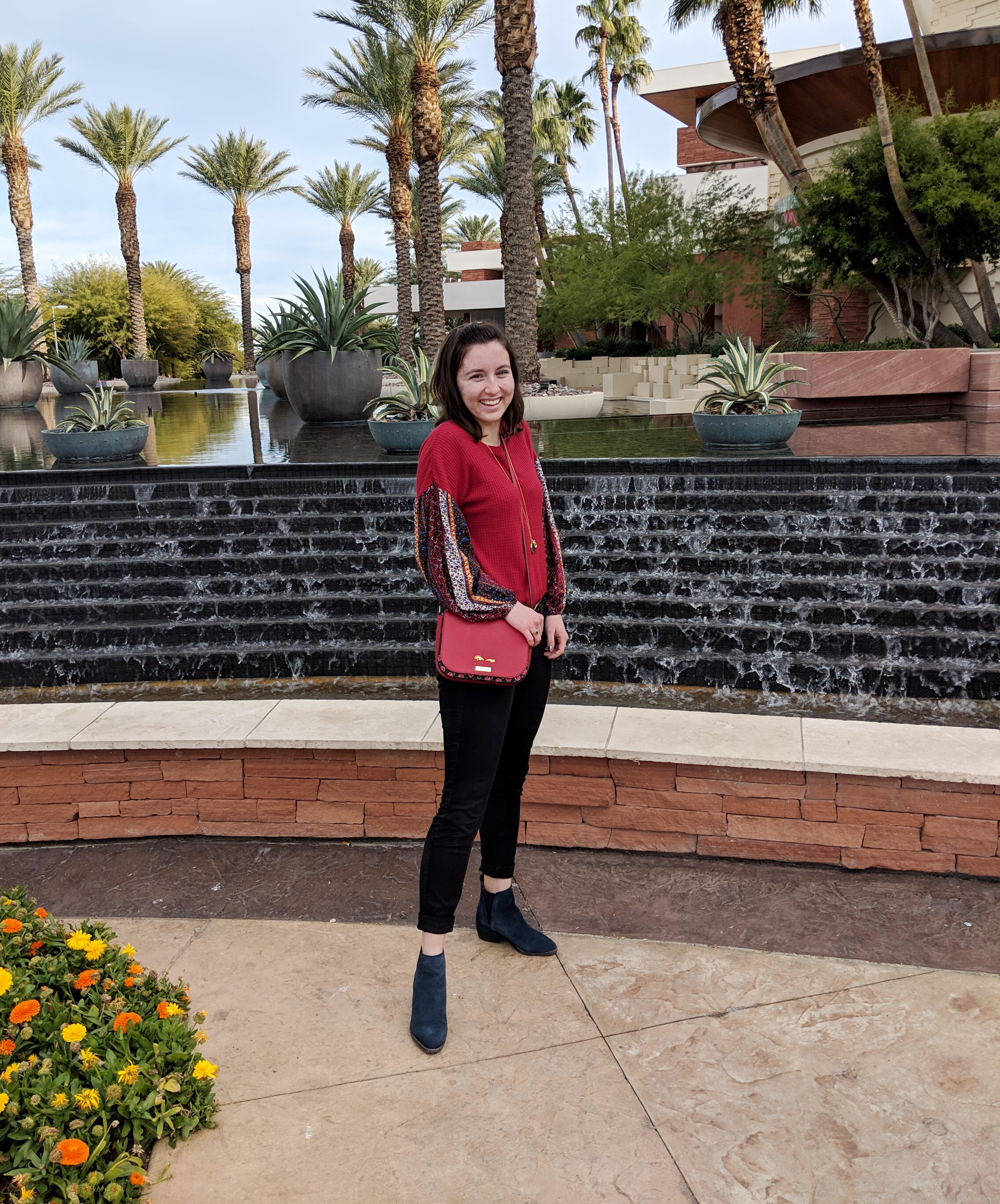 red patterned shirt red purse and black skinnies