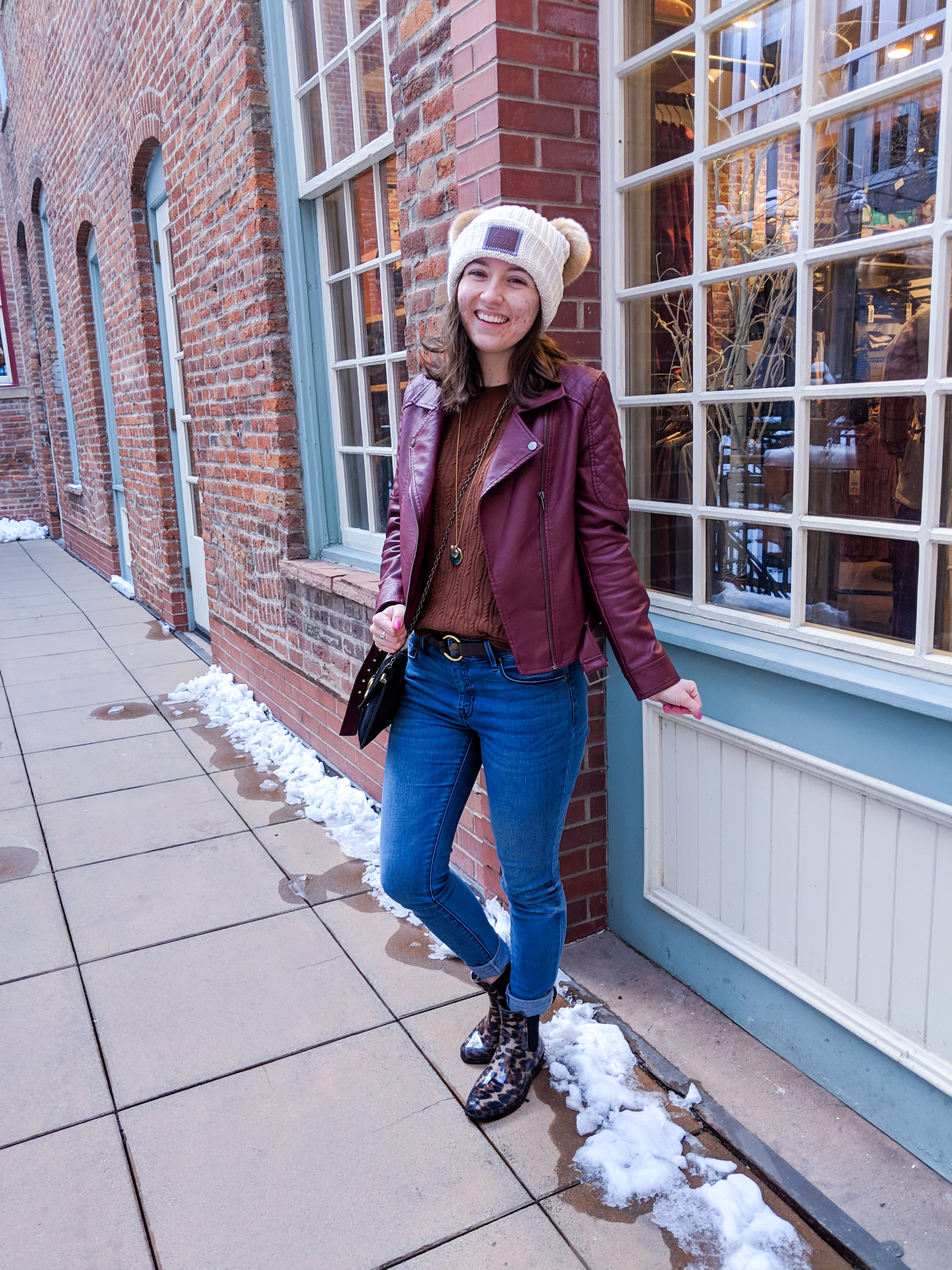 cream beanie, blue jeans, burgundy jacket, black purse, leopard boots