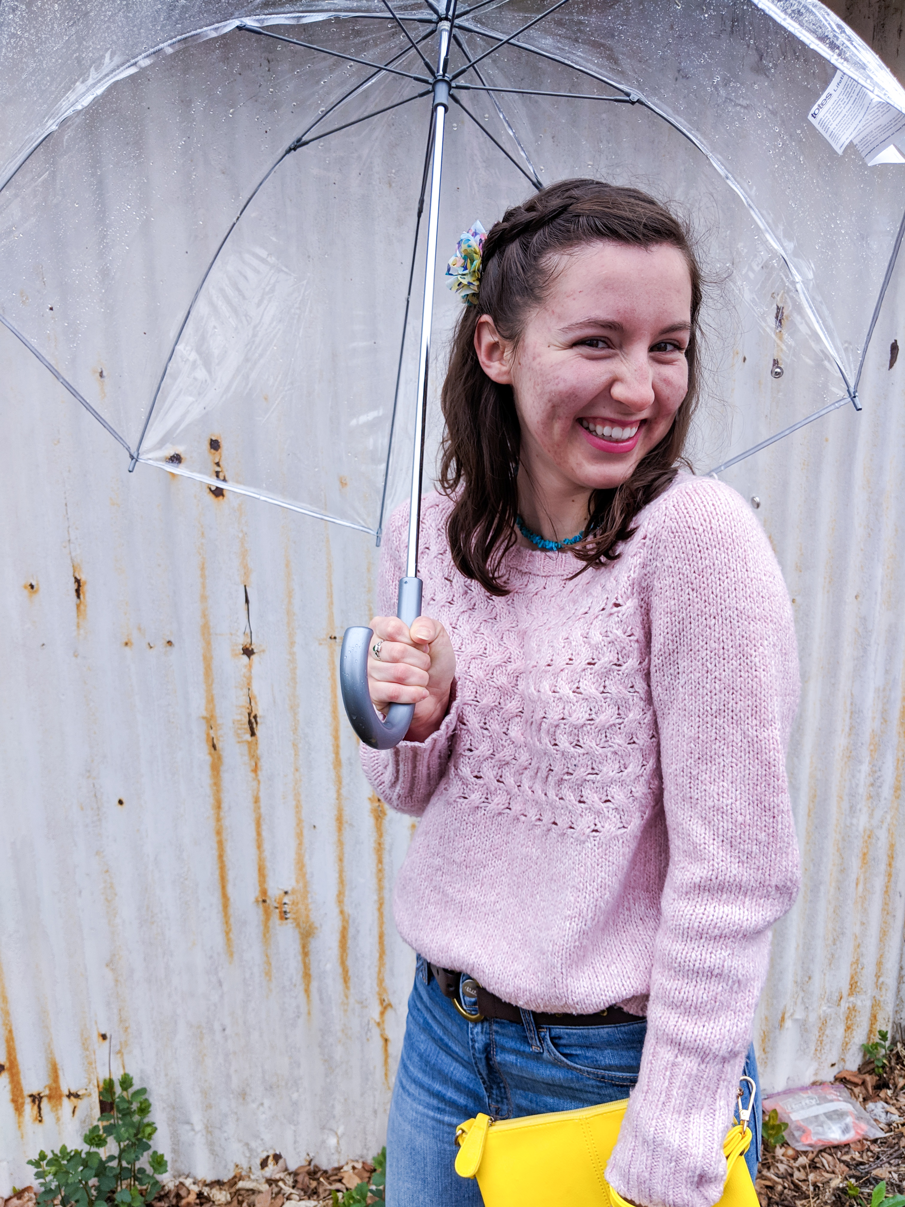 pink sweater, yellow clutch, clear umbrella