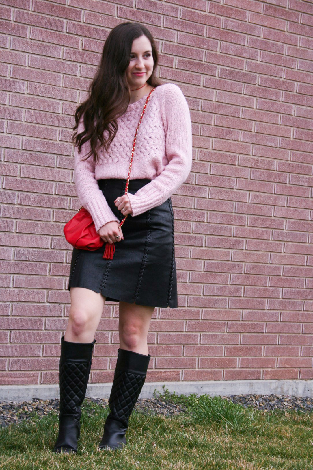 pink sweater, red purse, black pleather skirt, black boots