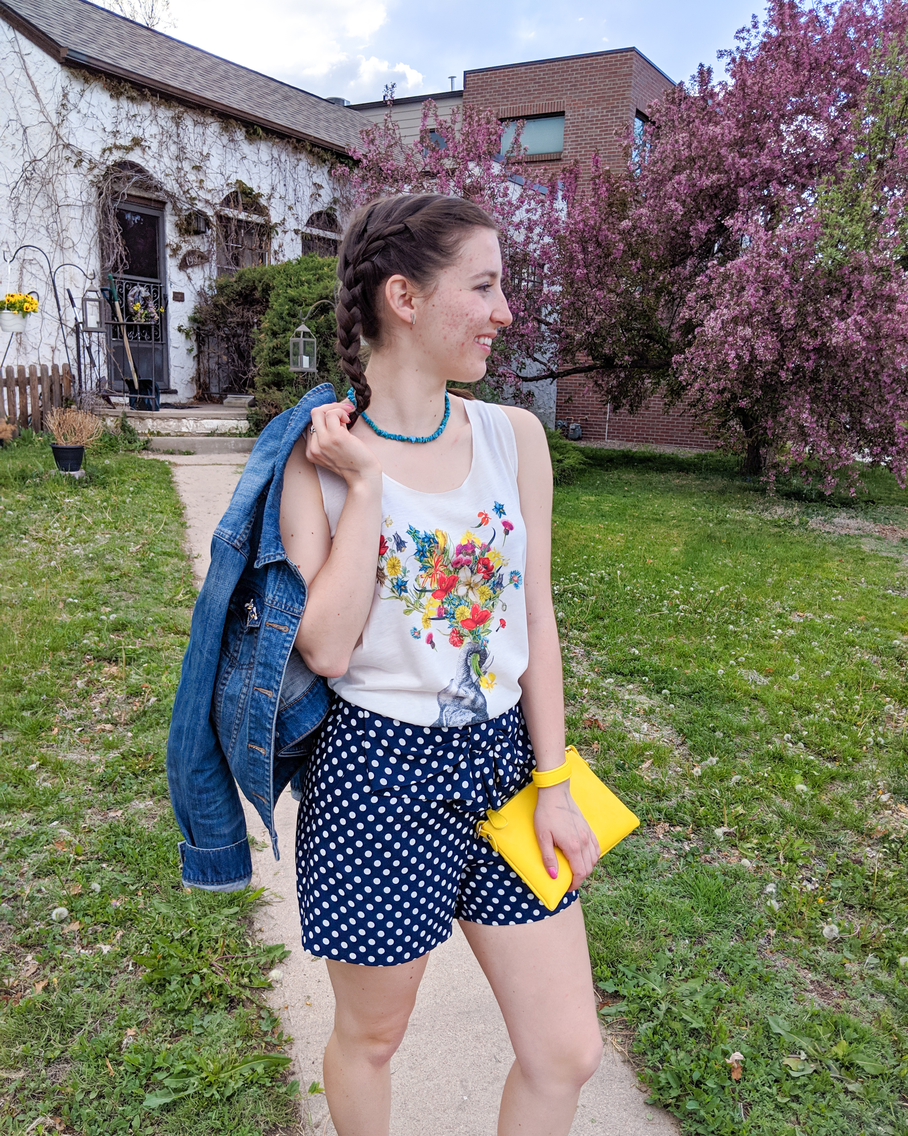 floral graphic tee, polka dot shorts, yellow purse, jean jacket