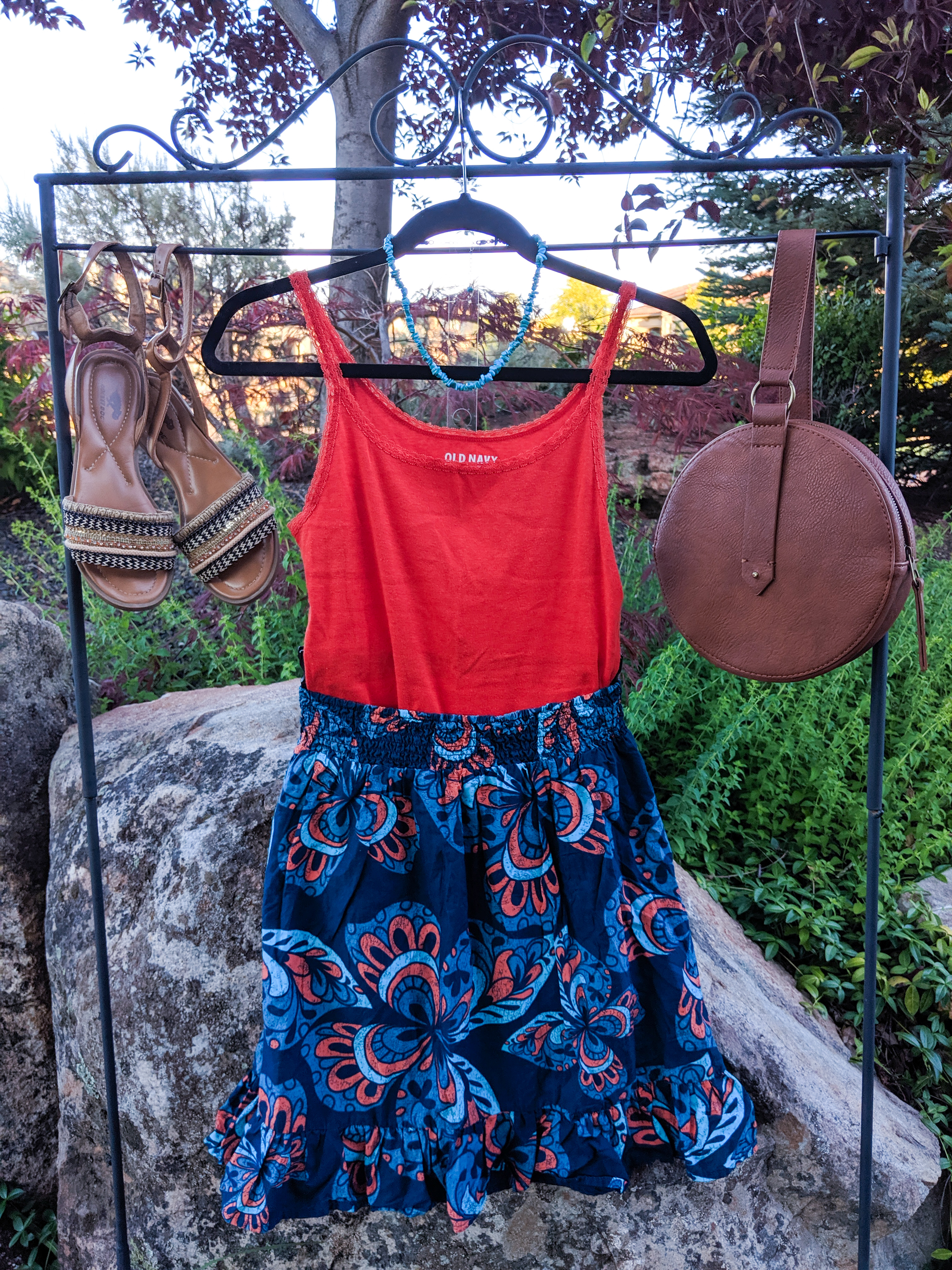 orange top, blue patterned skirt, brown accessories