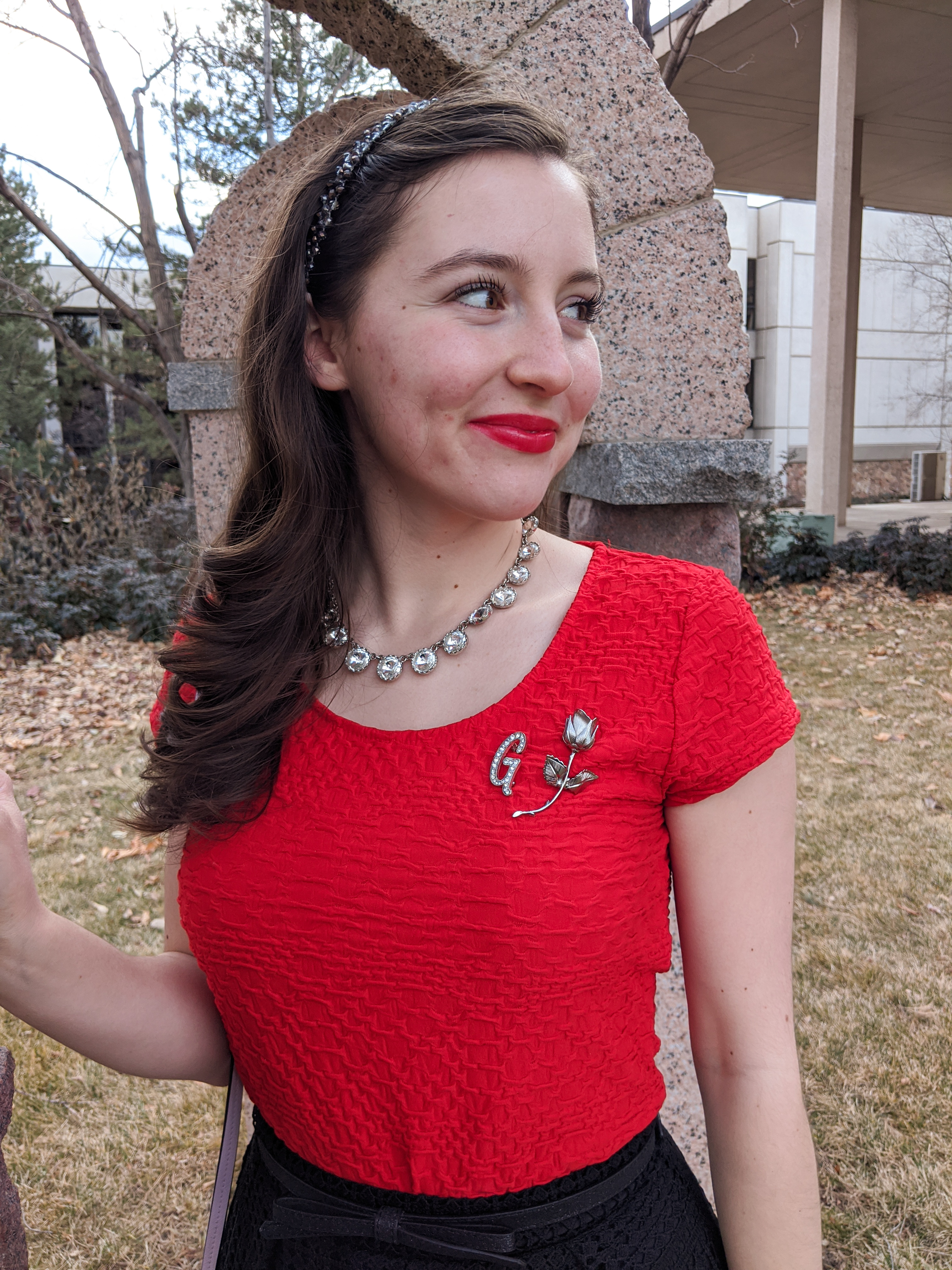 crystal statement necklace, red blouse, brooches, rose pin, red lipstick