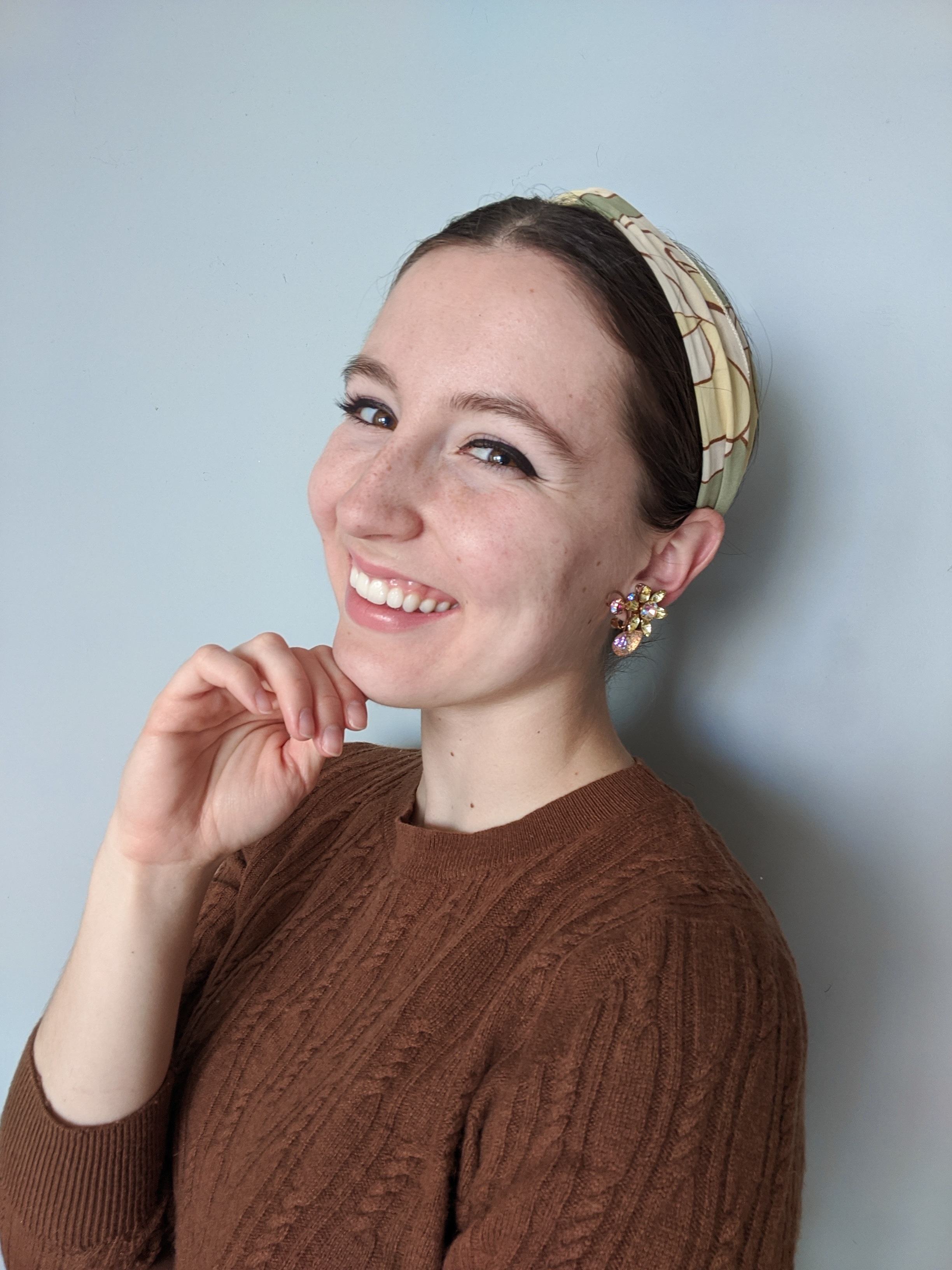 green hair scarf, brown sweater, statement earrings, winged eyeliner
