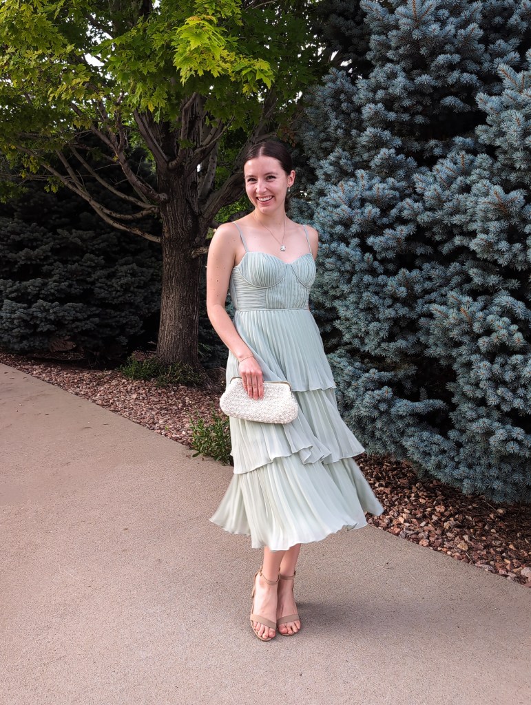 twirling sage green dress bustier pearl clutch nude heels